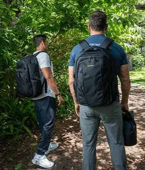Hiker wearing an EscapeZone Faraday backpack on a forest trail