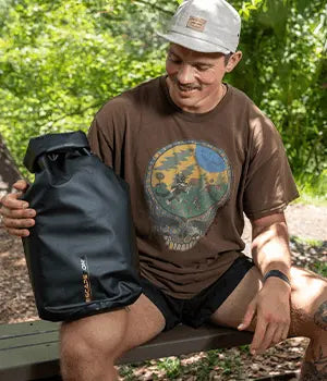 Hiker carrying an EscapeZone Faraday dry bag in the forest
