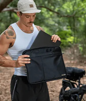 Man packing a laptop into an EscapeZone Faraday bag outdoors
